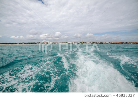 Motor trail on water surface behind of fast moving motor boat Motor trail on water surface behind of fast moving motor boat 46925327