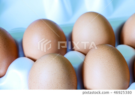 Yellow chicken eggs in a carton with empty space, background. Yellow chicken eggs in a carton with empty space, background. 46925380