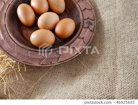 Eggs in copper plate on a brown sackcloth (burlap) Eggs in copper plate on a brown sackcloth (burlap) 46925683
