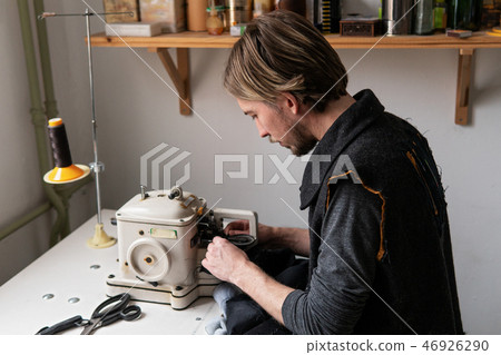 Man tailor working on furrier machine in workshop 46926290