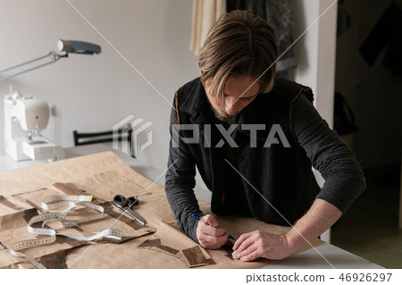 Man tailor making clothing pattern while work in workshop Man tailor making clothing pattern while work in workshop 46926297
