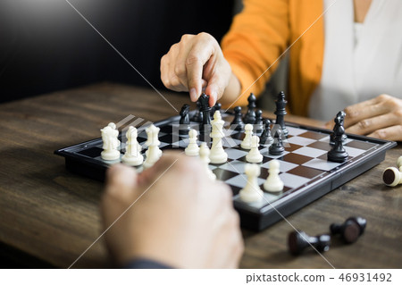 hand of businessman moving chess figure in competition board gam 46931492