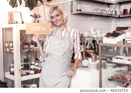 Joyful positive young woman opening her cafe Joyful positive young woman opening her cafe 46939754