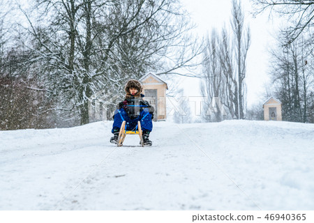 Boy with a sled at winter country Boy with a sled at winter country 46940365