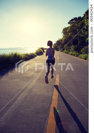 woman running on seaside trail in the morning woman running on seaside trail in the morning 46940494