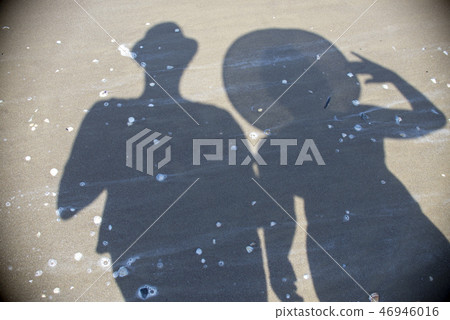 shadow of two tourists on the beach shadow of two tourists on the beach 46946016
