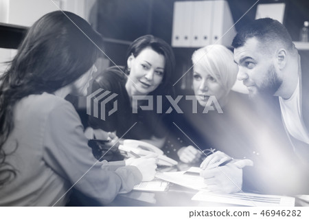 Smiling employees talking in workplace Smiling employees talking in workplace 46946282