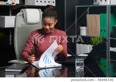 spectacular young black businesswoman signs documents at table in office spectacular young black businesswoman signs documents at table in office 46946336