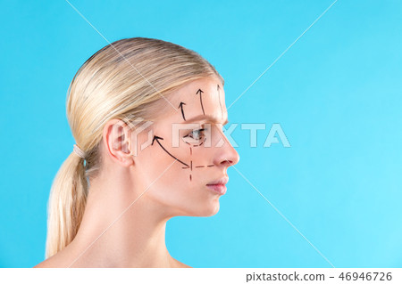 Beautiful Woman Face. Beauty Portrait of young woman blond, painted lines on the face for cosmetic Beautiful Woman Face. Beauty Portrait of young woman blond, painted lines on the face for cosmetic 46946726
