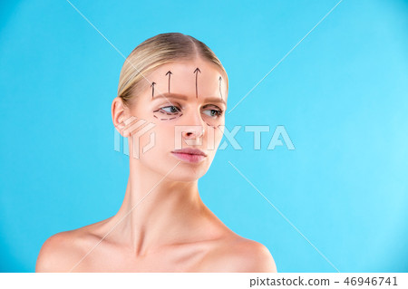 Beautiful Woman Face. Beauty Portrait of young woman blond, painted lines on the face for cosmetic Beautiful Woman Face. Beauty Portrait of young woman blond, painted lines on the face for cosmetic 46946741