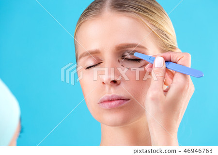 Cosmetic surgeon examining female client in office. Doctor draws lines with a marker, the eyelid 46946763