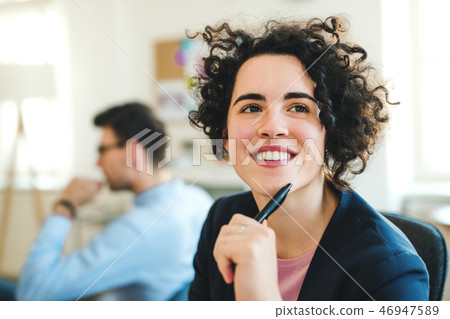 A portrait of young businesswoman with colleagues in a modern office. A portrait of young businesswoman with colleagues in a modern office. 46947589