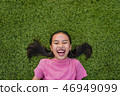 kid asian girl's lie leisurely on the Lawn floor 46949099
