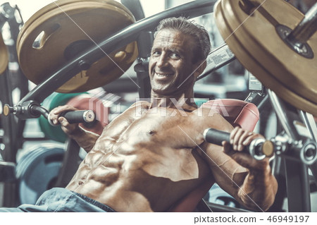 Brutal aged strong bodybuilder athletic men pumping up muscles w 46949197