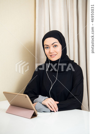 Arabic woman using tablet pc computer. Southeast Asian student at home. Muslim teenage girl living 46950831