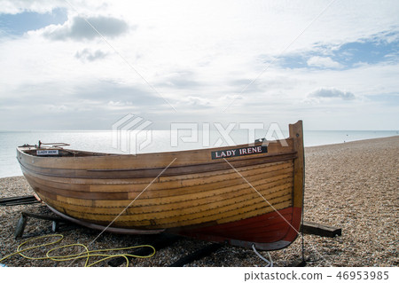 A single wooden boat listed on gravel beach A single wooden boat listed on gravel beach 46953985