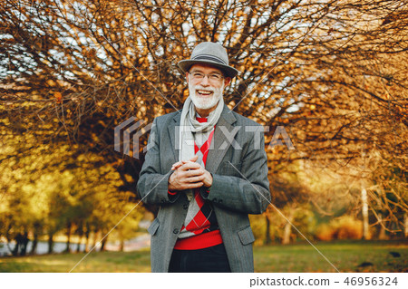 Elegant old man in a sunny autumn park Elegant old man in a sunny autumn park 46956324