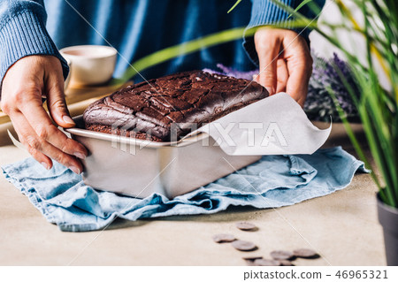 Woman composing chocolate bread in form 46965321