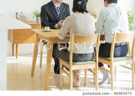 Businessman explaining to middle aged couple 46965973