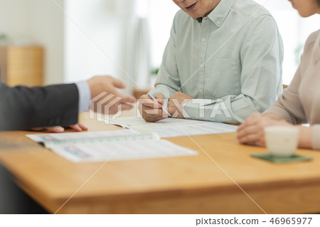 Businessman explaining to middle aged couple 46965977