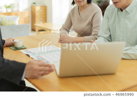 Businessman explaining to middle aged couple 46965990