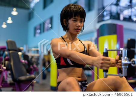 Young woman working back with seated cable row Young woman working back with seated cable row 46966561