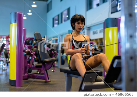 Young woman working back with seated cable row Young woman working back with seated cable row 46966563
