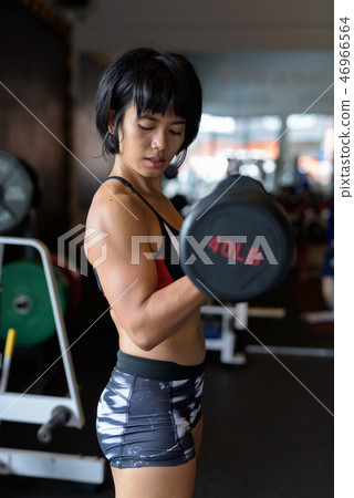 Fitness woman doing dumbbell bicep girl at gym Fitness woman doing dumbbell bicep girl at gym 46966564