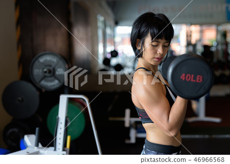 Fitness woman doing dumbbell bicep girl at gym Fitness woman doing dumbbell bicep girl at gym 46966568