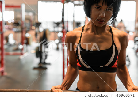 Young beautiful Asian woman working out at the gym 46966571