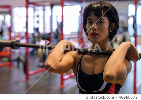 Young beautiful Asian woman working out at the gym Young beautiful Asian woman working out at the gym 46966572