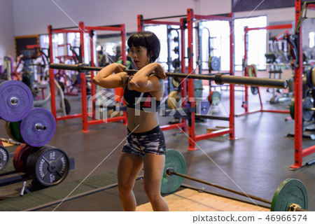 Young beautiful Asian woman working out at the gym Young beautiful Asian woman working out at the gym 46966574