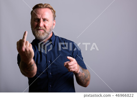 Mature bearded man with hand tattoos showing middle finger 46966822