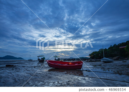 a small red fishing boat on the beach a small red fishing boat on the beach 46969334