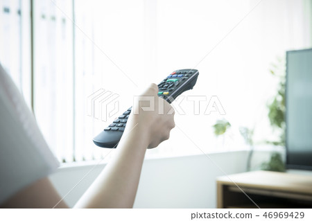 操作電視遙控的女性手 操作電視遙控的女性手 46969429