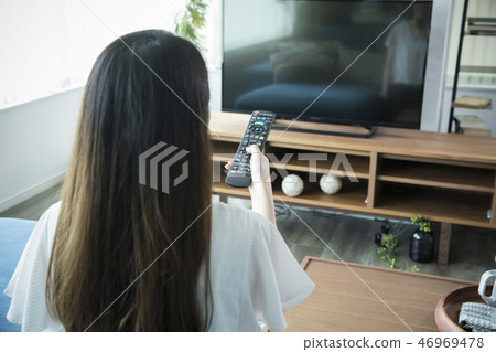 操作電視遙控的婦女 操作電視遙控的婦女 46969478