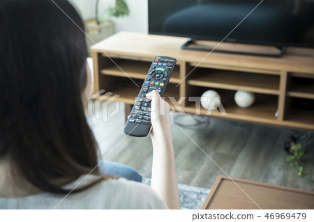 操作電視遙控的婦女 操作電視遙控的婦女 46969479