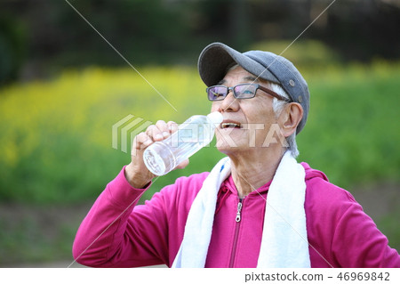 Elderly men drinking water of PET bottles between outdoor exercise 46969842