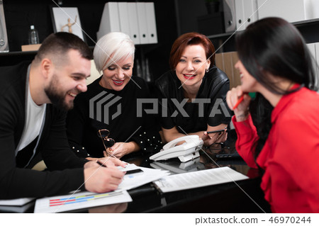 Smiling employees talking in workplace 46970244