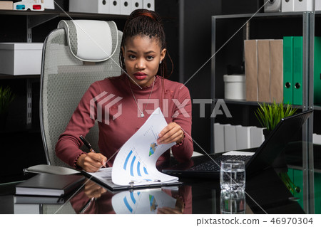 spectacular young black businesswoman signs documents at table in office 46970304