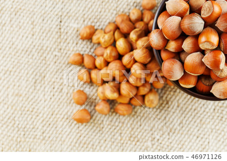 Peeled hazelnuts in a wooden, dark brown cup on Peeled hazelnuts in a wooden, dark brown cup on 46971126