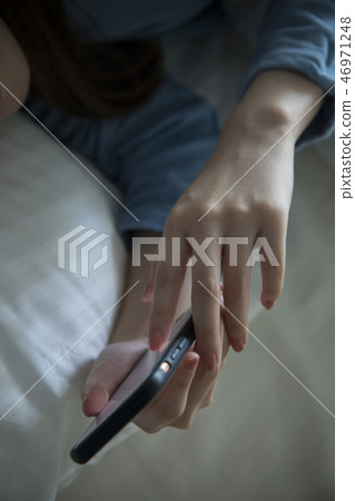 女性手在床上的操作一個智能手機 46971248