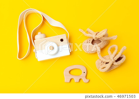 Wooden toys and shoes on a yellow background.  46971503