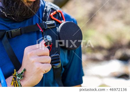 Torso of equipped hiker with speaker, compass and water pipe 46972136