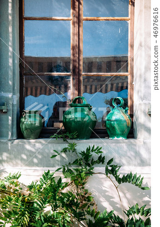 Old green ceramic pottery at old wooden window 46976616