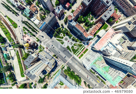 Aerial city view with crossroads and roads, houses, buildings, parks and parking lots. Sunny summer 46979080
