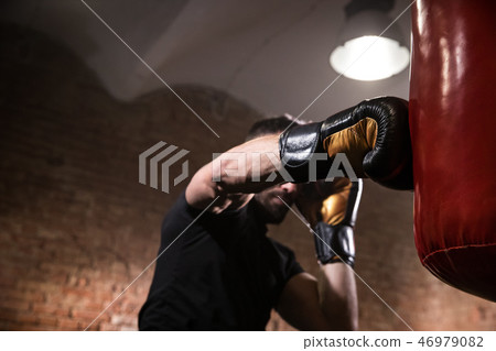 Hand of boxer at the moment of impact on punching bag. 46979082