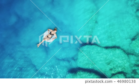 Aerial view at the girl on sea surface. Aerial view at the girl on sea surface. 46980138