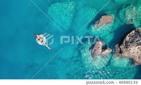 Aerial view at the girl on sea surface. Aerial view at the girl on sea surface. 46980139