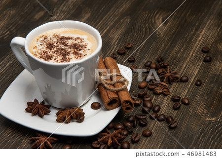 Cup of coffee on dark background. With cinnamon sticks, coffee beans and star anise 46981483